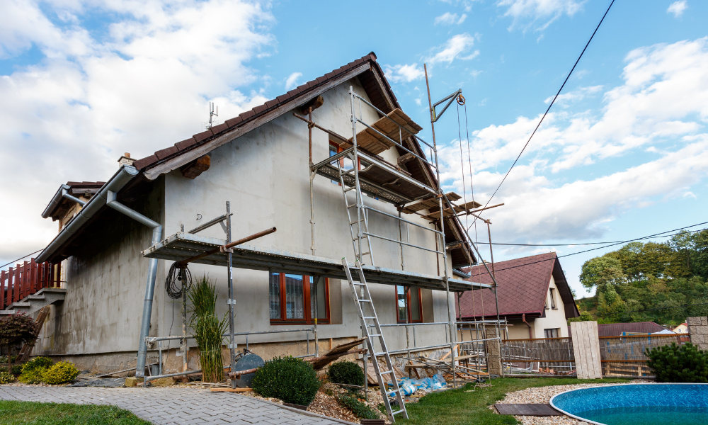 homlokzati hőszigetelés: egy kétemeletes, kertes ház medencével oldalról, előtte rámpa létrával